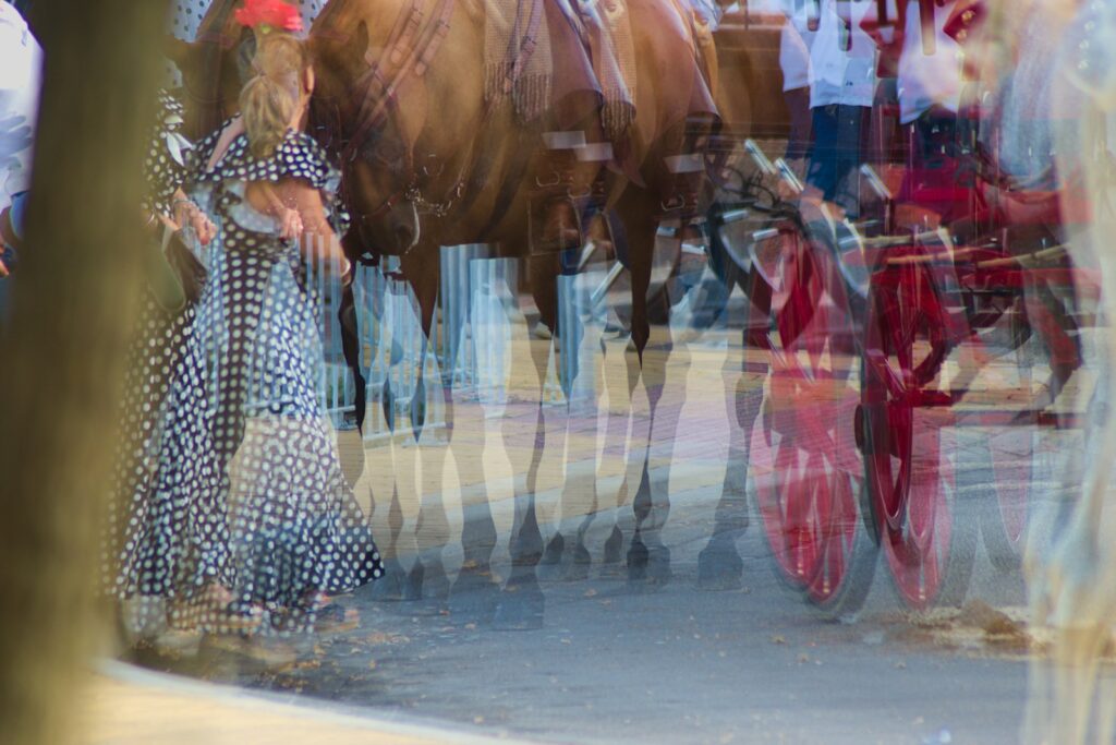 Woman in a polka dot dress standing beside a horse and carriage, showing a classic occasion dress